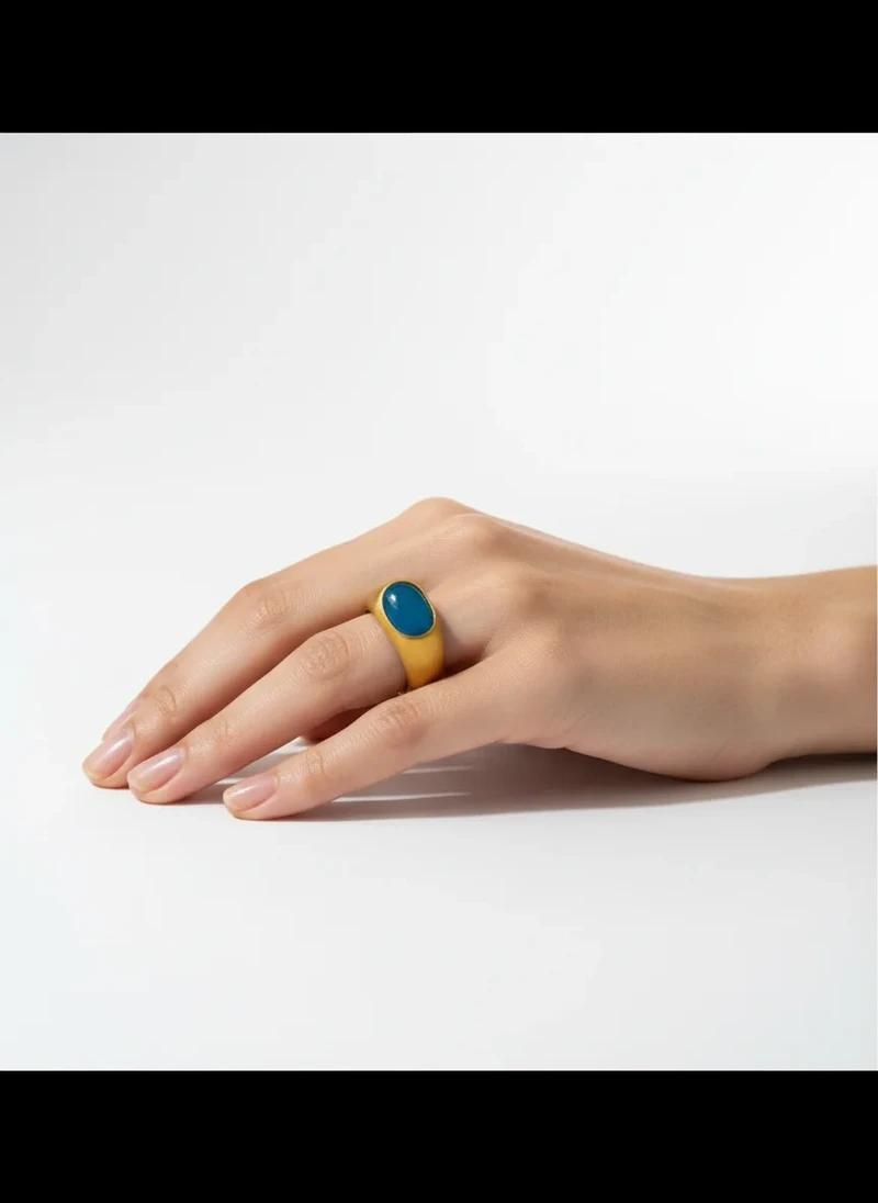 Gold ring with teal oval gemstone.
