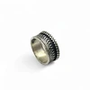 Silver ring with ornate patterned band.