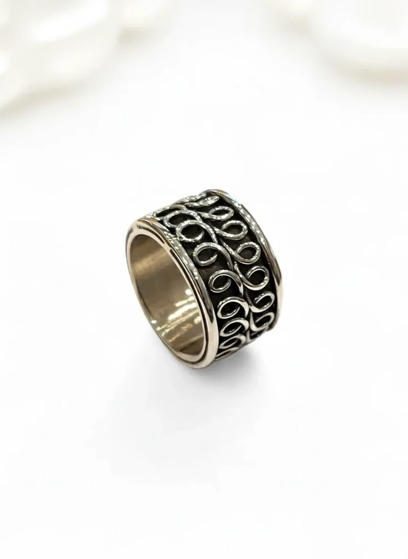 Silver ring with ornate band.