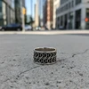 Silver ring with ornate swirling design.
