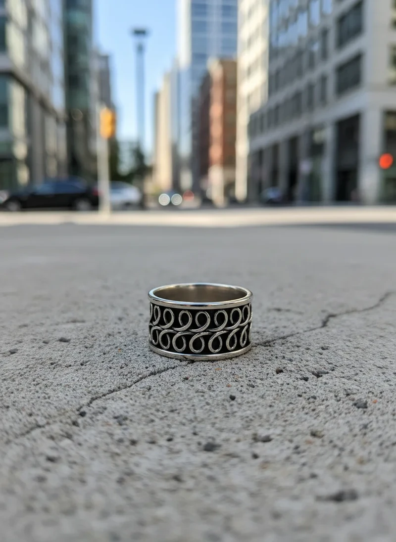 Silver ring with ornate swirling design.