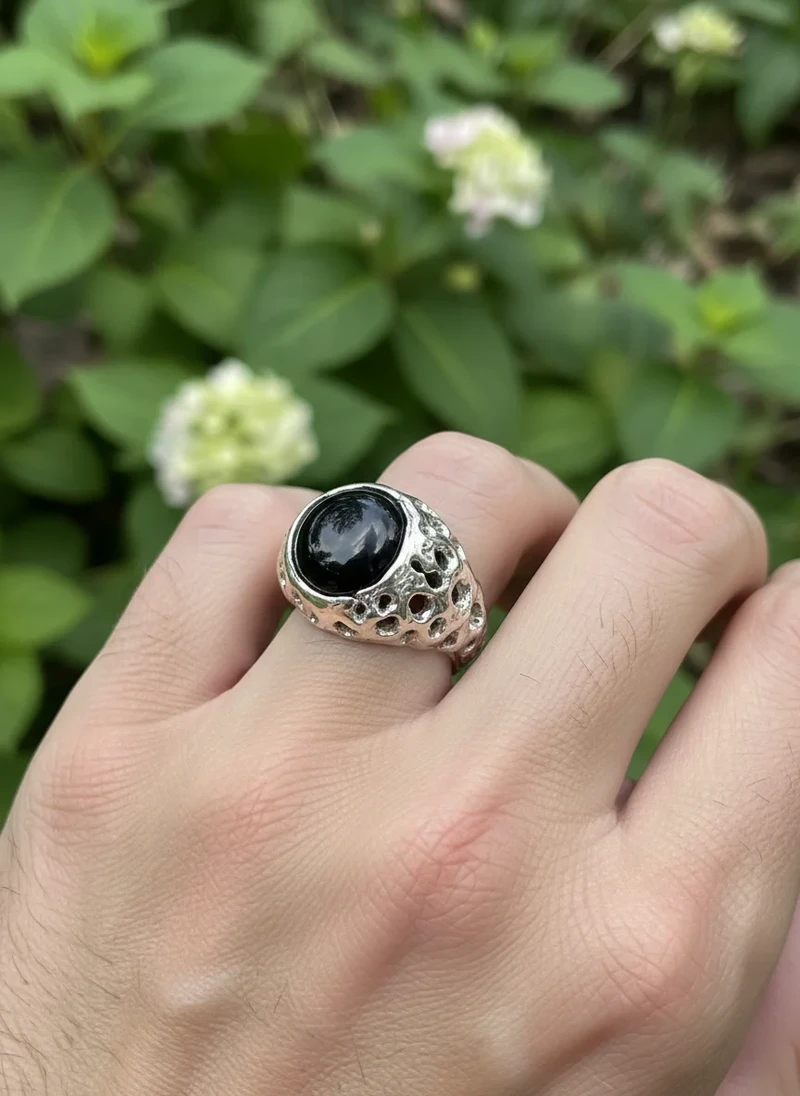 Black stone signet ring with silver, textured band.