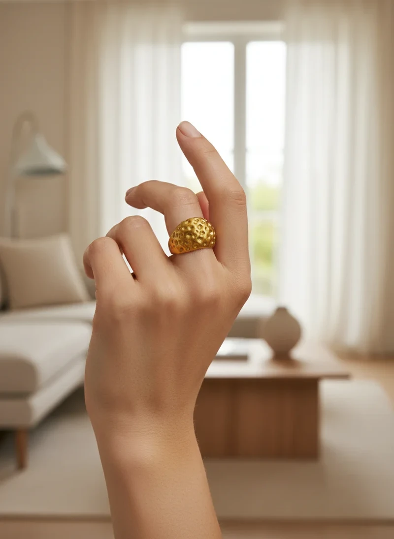 Gold textured dome ring on hand.
