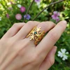 Gold ring with blue gemstone & ornate design.