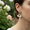 Gold hoop earrings with pearl charm clusters.