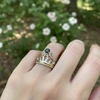 Gold crown ring with black gemstone.