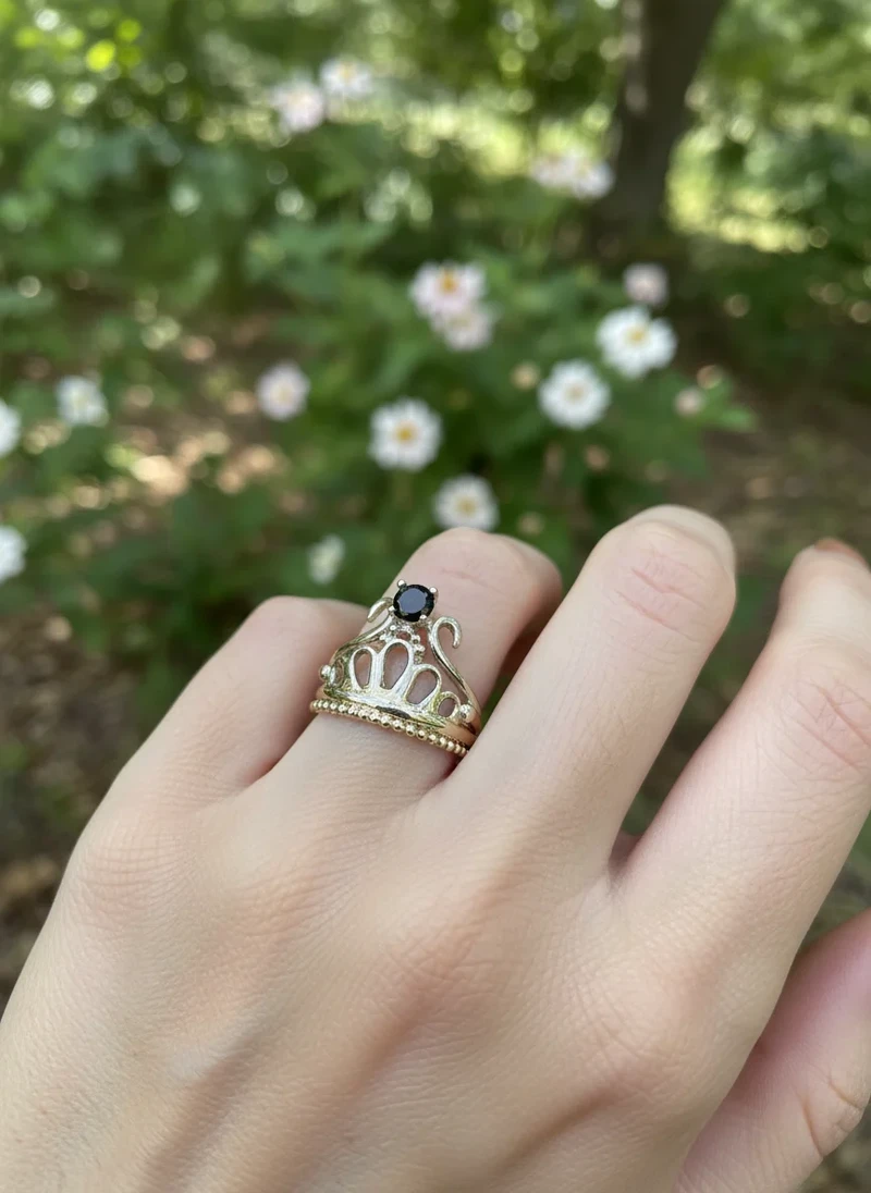 Gold crown ring with black gemstone.