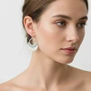 Silver half-moon earrings with ornate detail.