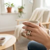 Woman's hand wearing a silver statement ring, holding a mug.