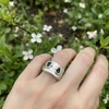 Silver ring with black hamsa charms.