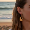 Gold teardrop earrings with floral detail.