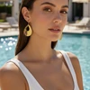 Gold teardrop earrings with cutout detailing.