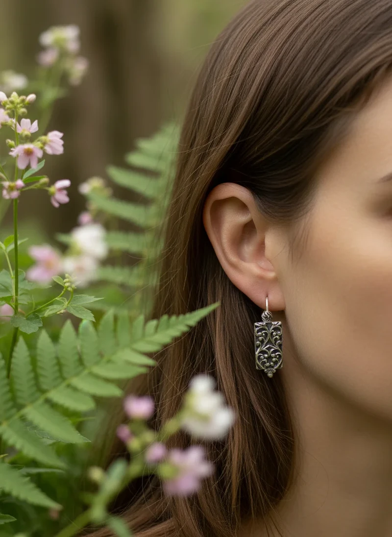 Silver filigree earrings on model.