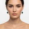 Woman wearing dark green stone necklace & earrings.