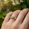 Ornate gold band ring on hand.
