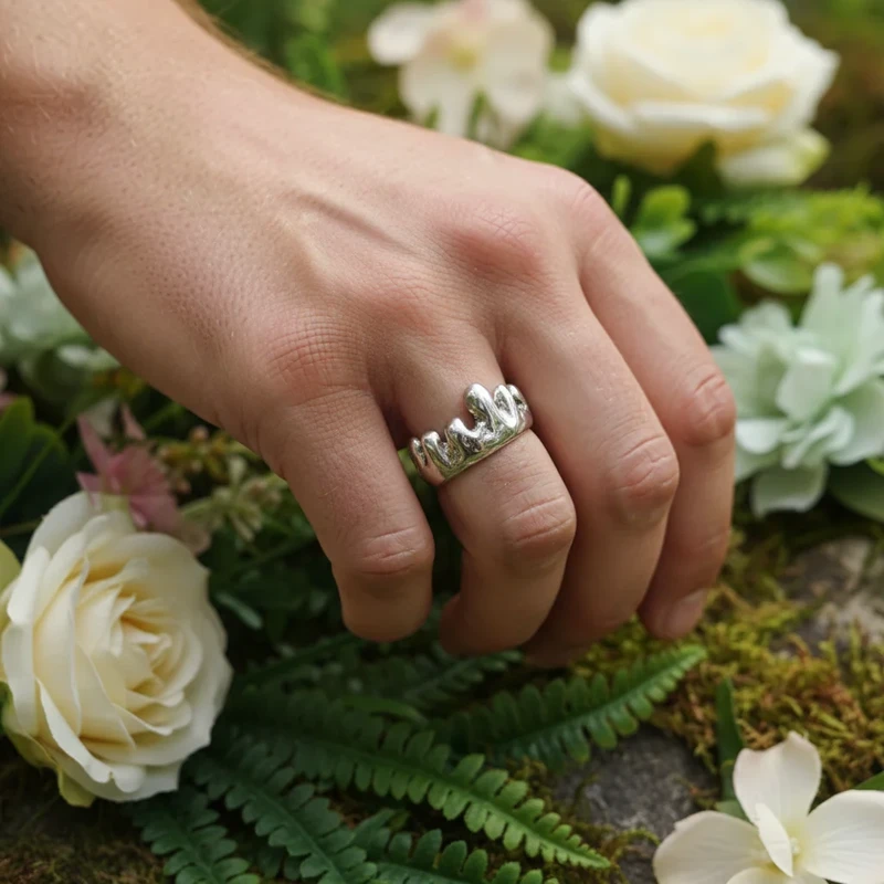 Silver crown ring on hand.