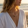 Woman wearing silver beaded necklace.