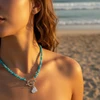 Blue gemstone heart necklace on model.