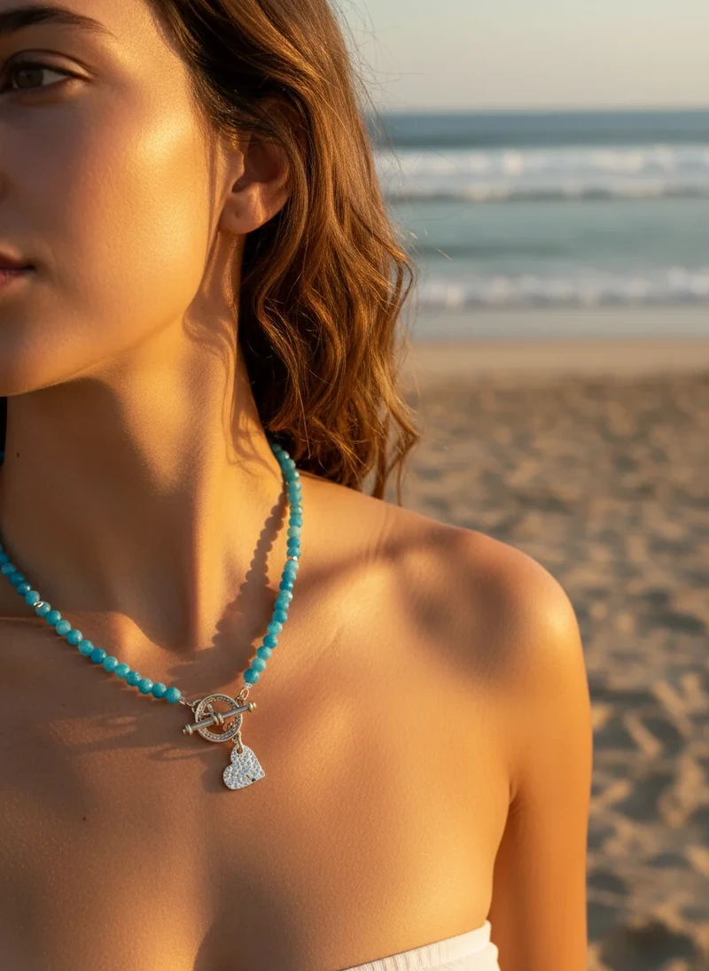 Blue gemstone heart necklace on model.