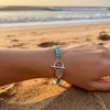 Beaded turquoise bracelet with silver heart charm.