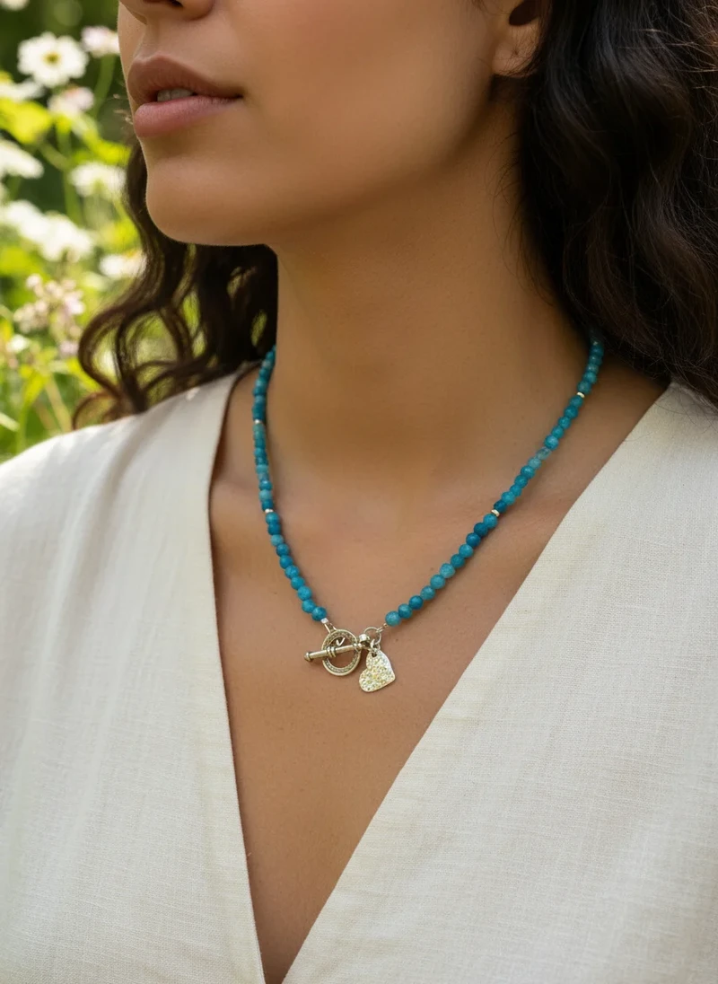 Teal gemstone beaded necklace with silver heart charm.