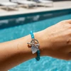 Teal beaded bracelet with silver heart charm.