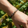 Men's beaded leather bracelet with silver and gold accents.
