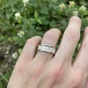 Silver band ring with vertical textured detail.