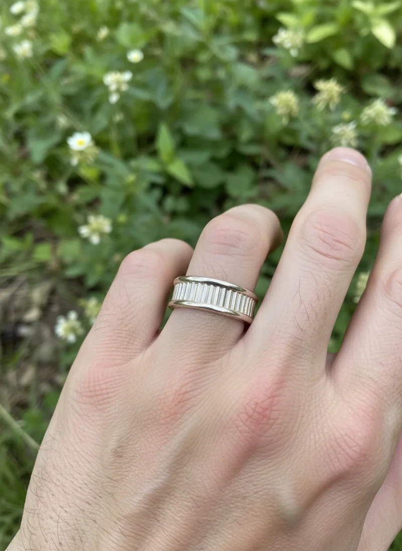 Silver band ring with vertical textured detail.
