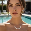 Gold pearl necklace on model by pool.