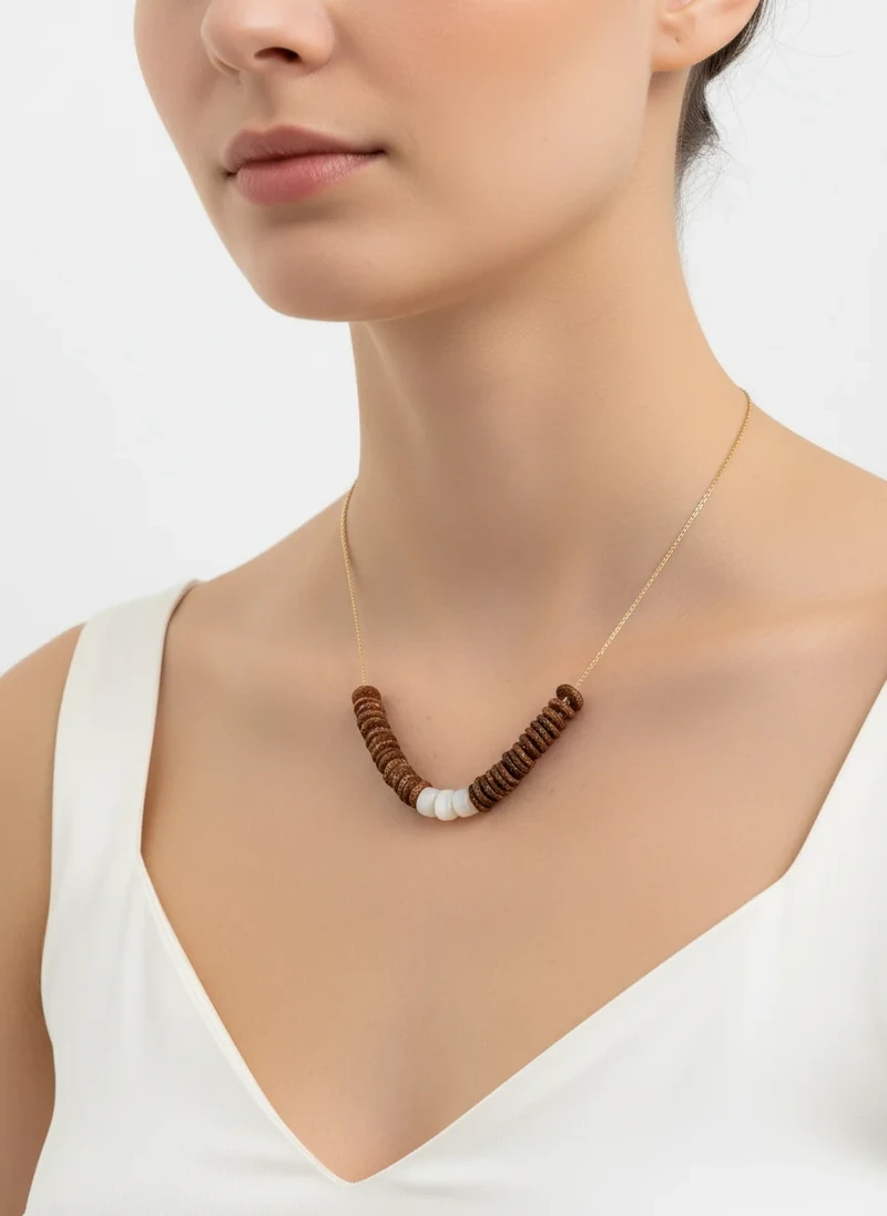 Gold chain necklace with brown wood and white shell beads.