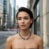Woman wearing dark pearl necklace with flower charms.