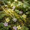Silver filigree heart locket necklace on moss.