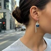 Silver dangle earrings with dark blue bead.