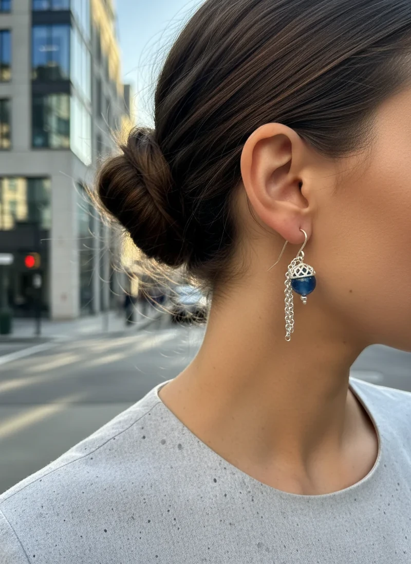 Silver dangle earrings with dark blue bead.
